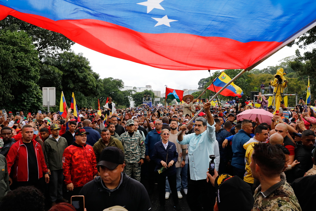 President Nicolas Maduro waves a flag during a rally marking the anniversary of the Battle of Santa Ines, which took place during Venezuela's 19th-century Federal War, in Caracas, Venezuela, Wednesday, Dec. 10, 2025. (AP Photo:Cristian Hernandez)